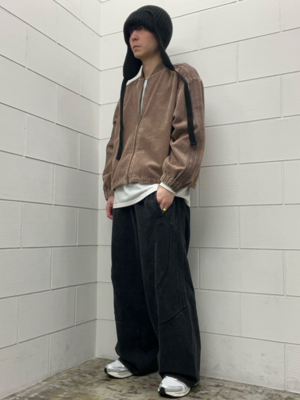 ブラウン系のブルゾン、シルバー系のスニーカー、ブラック系のその他パンツを着用したメンズの冬コーディネートの2枚目の写真