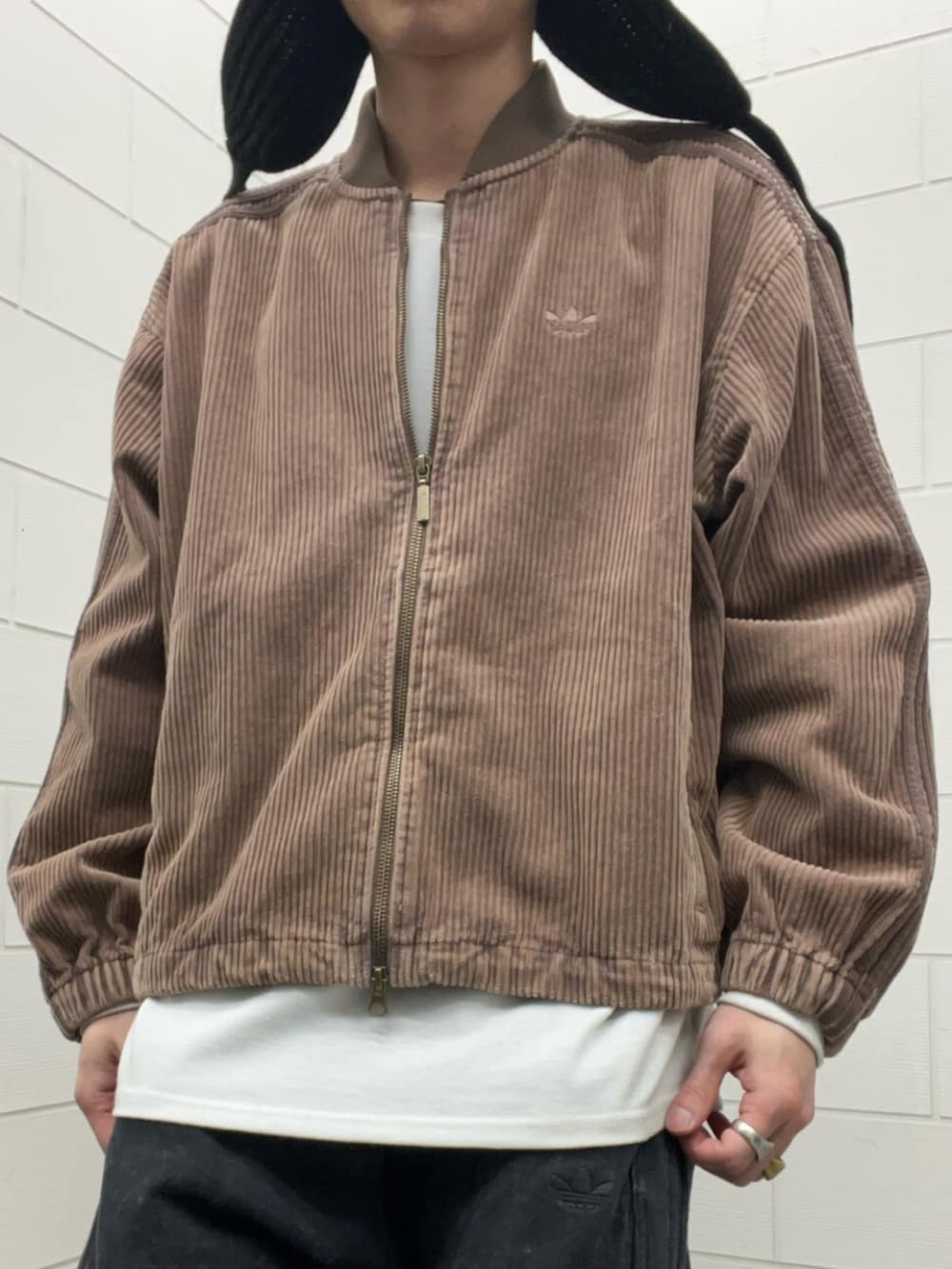 ブラウン系のブルゾン、シルバー系のスニーカー、ブラック系のその他パンツを着用したメンズの冬コーディネートの4枚目の写真