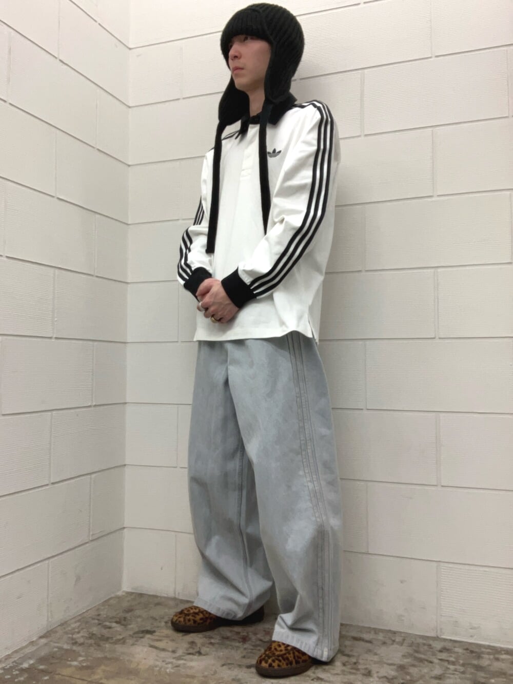 ブルー系のその他パンツ、ベージュ系のスニーカー、ホワイト系のポロシャツを着用したメンズの春コーディネートの2枚目の写真