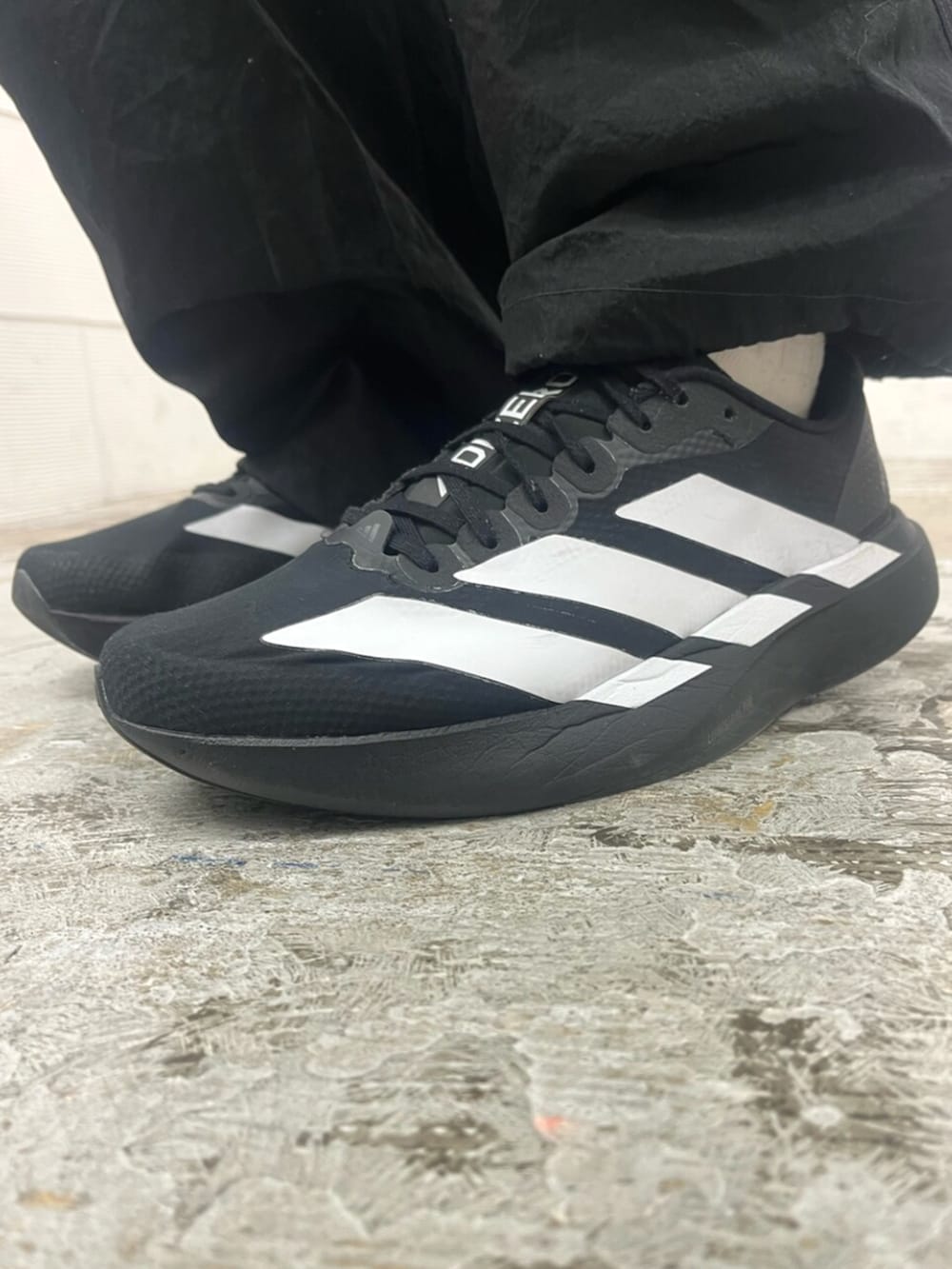 ブラック系のその他パンツ、ブラック系のスニーカー、グリーン系のトップスを着用したメンズの春コーディネートの6枚目の写真