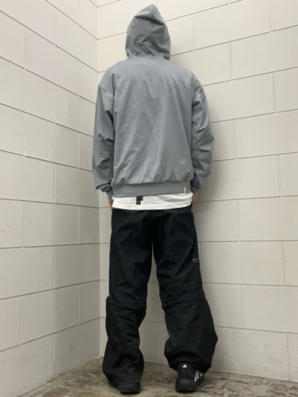 ブラック系のその他パンツ、ブラック系のスニーカー、グレー系のパーカーを着用したメンズの冬コーディネートの3枚目の写真