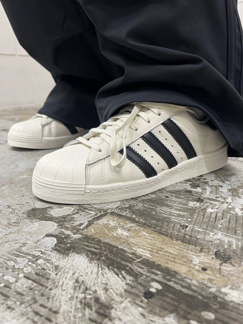 ホワイト系のシューズ、ブラック系のTシャツ/カットソー、ブラック系のその他パンツを着用したメンズの春コーディネートの6枚目の写真