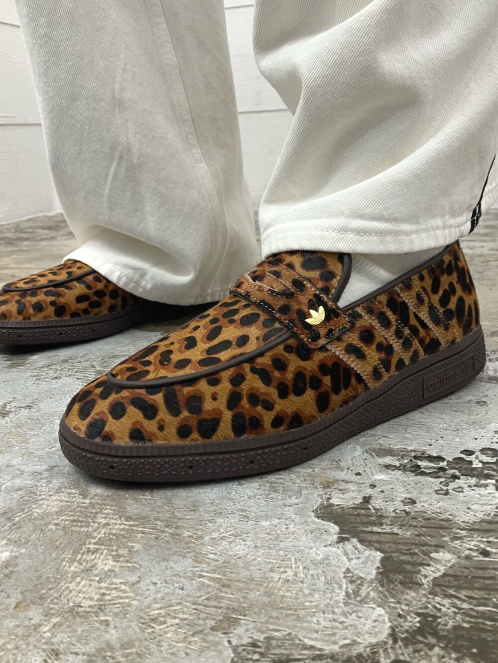 ベージュ系のスニーカー、ブラック系のポロシャツを着用したメンズの春コーディネートの6枚目の写真