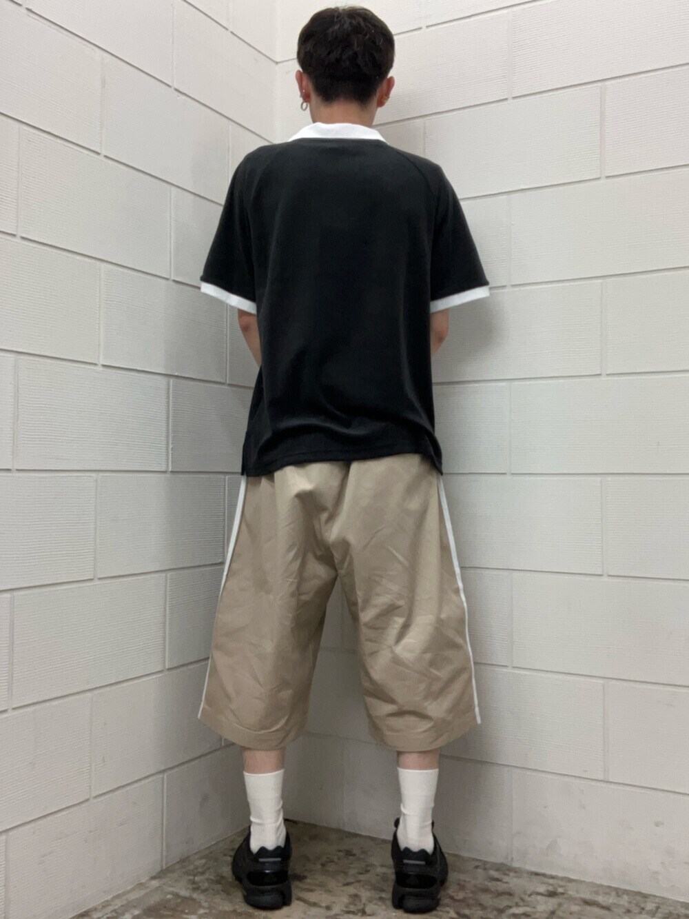 ブラック系のスニーカー、ブラック系のトップス、ベージュ系のその他パンツを着用したメンズの夏コーディネートの3枚目の写真