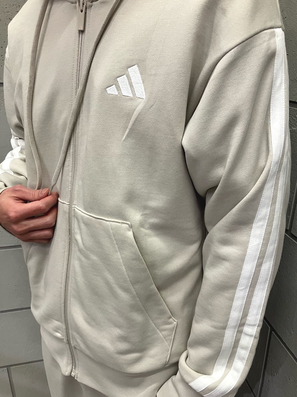 ホワイト系のスウェット、グレー系のスウェットパンツ、ブラック系のスニーカーを着用したメンズの冬コーディネートの2枚目の写真