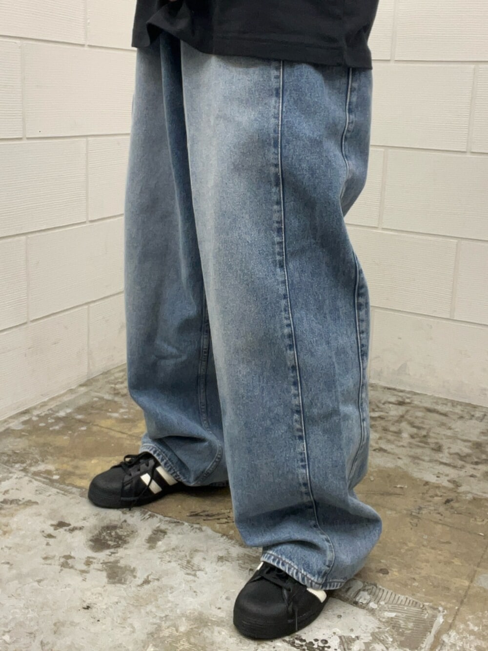 ブラック系のシューズ、ブルー系のデニムパンツ、ブラック系のTシャツ/カットソーを着用したメンズの春コーディネートの5枚目の写真