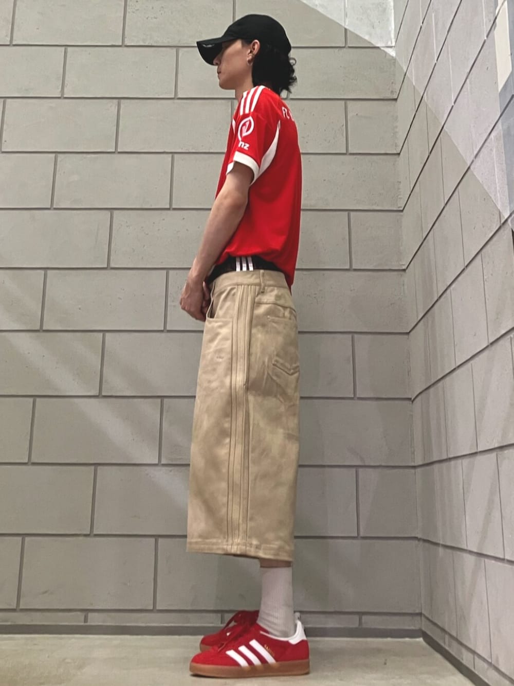 ベージュ系のその他パンツ、レッド系のスニーカー、レッド系のTシャツ/カットソーを着用したメンズの夏コーディネートの2枚目の写真