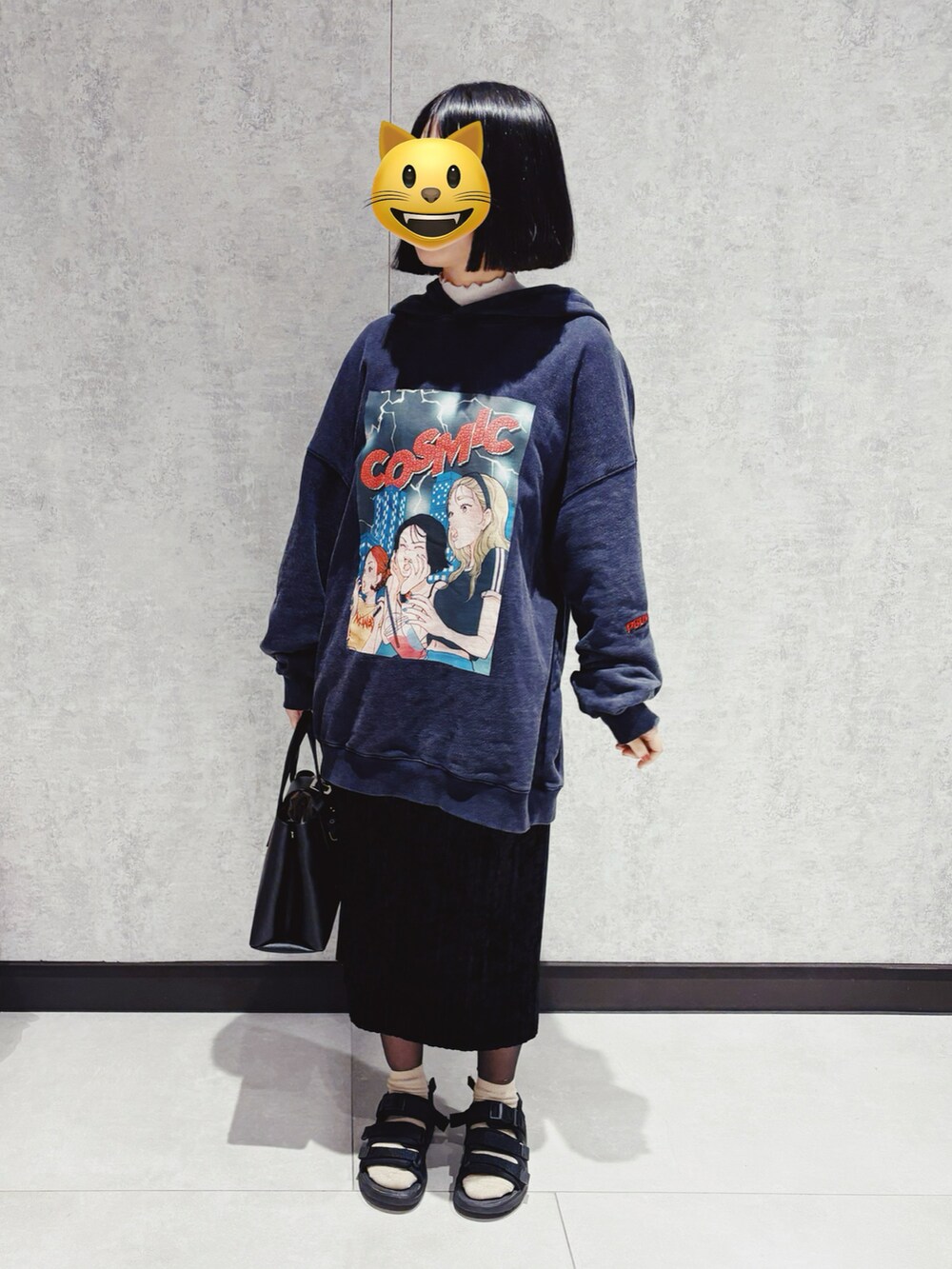 ブルー系のパーカー、ブラック系のトートバッグ、ブラック系のスカートを着用したレディースの春コーディネートの2枚目の写真