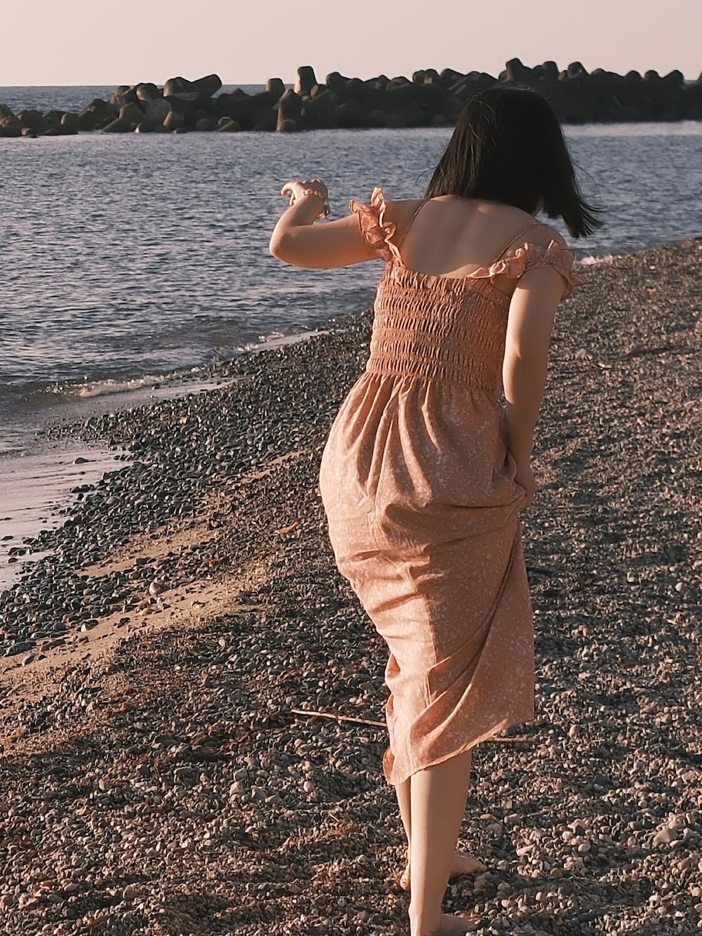 オレンジ系のワンピースを着用したレディースの夏コーディネートの3枚目の写真