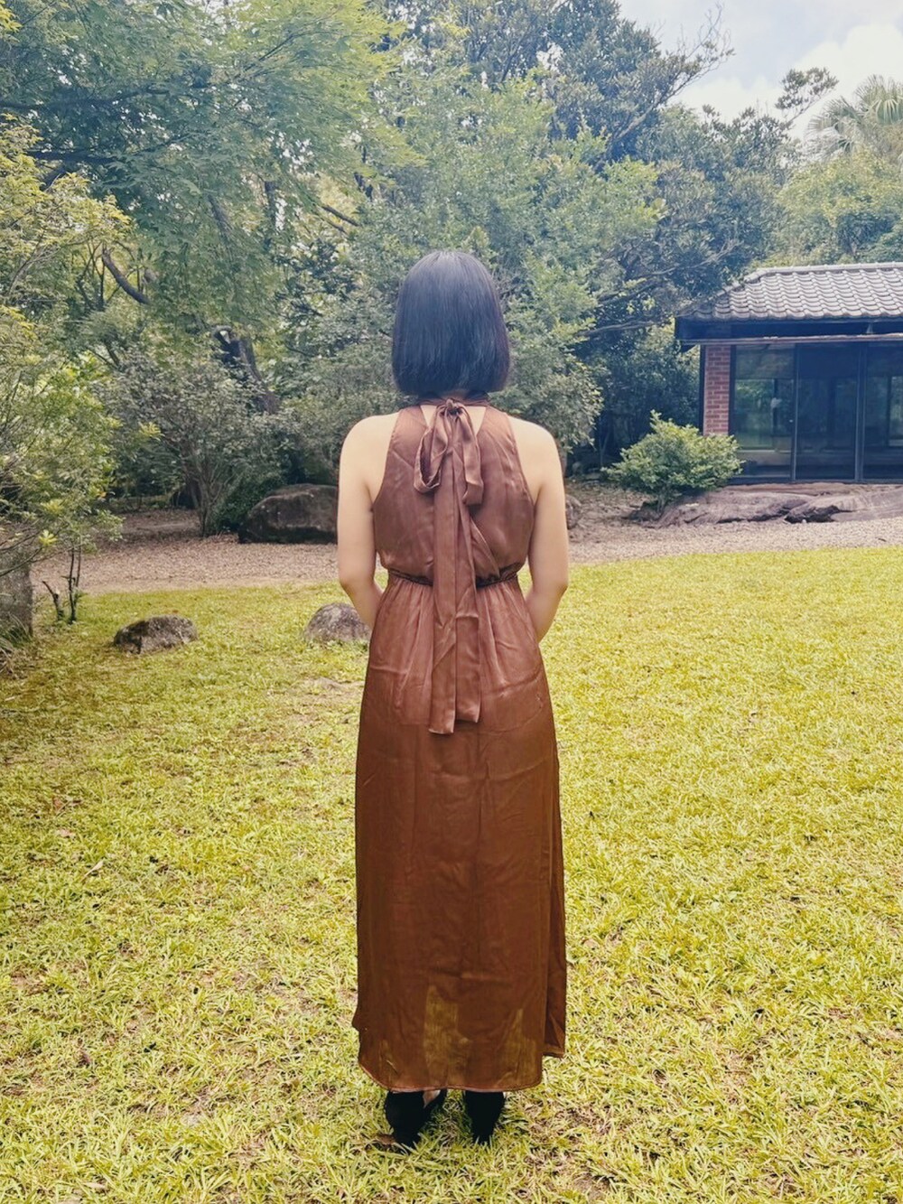 ブラウン系のワンピース、ブラック系のパンプスを着用したレディースの春コーディネートの2枚目の写真