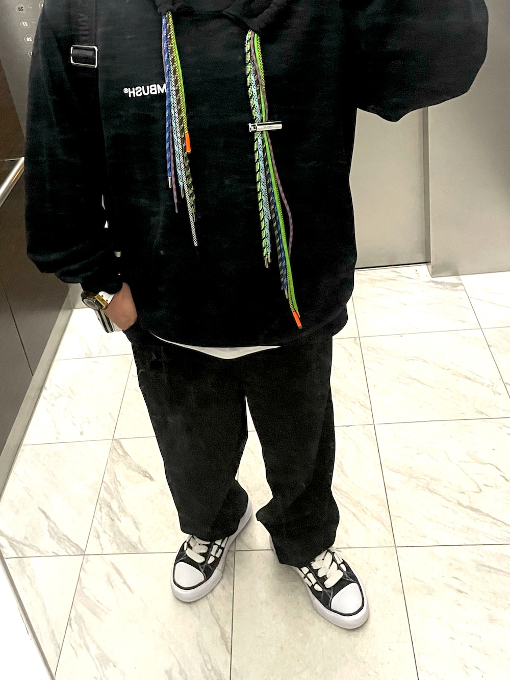 ブラック系のパーカー、ブラック系のその他パンツ、ブラック系のスニーカーを着用したメンズの秋コーディネートの2枚目の写真