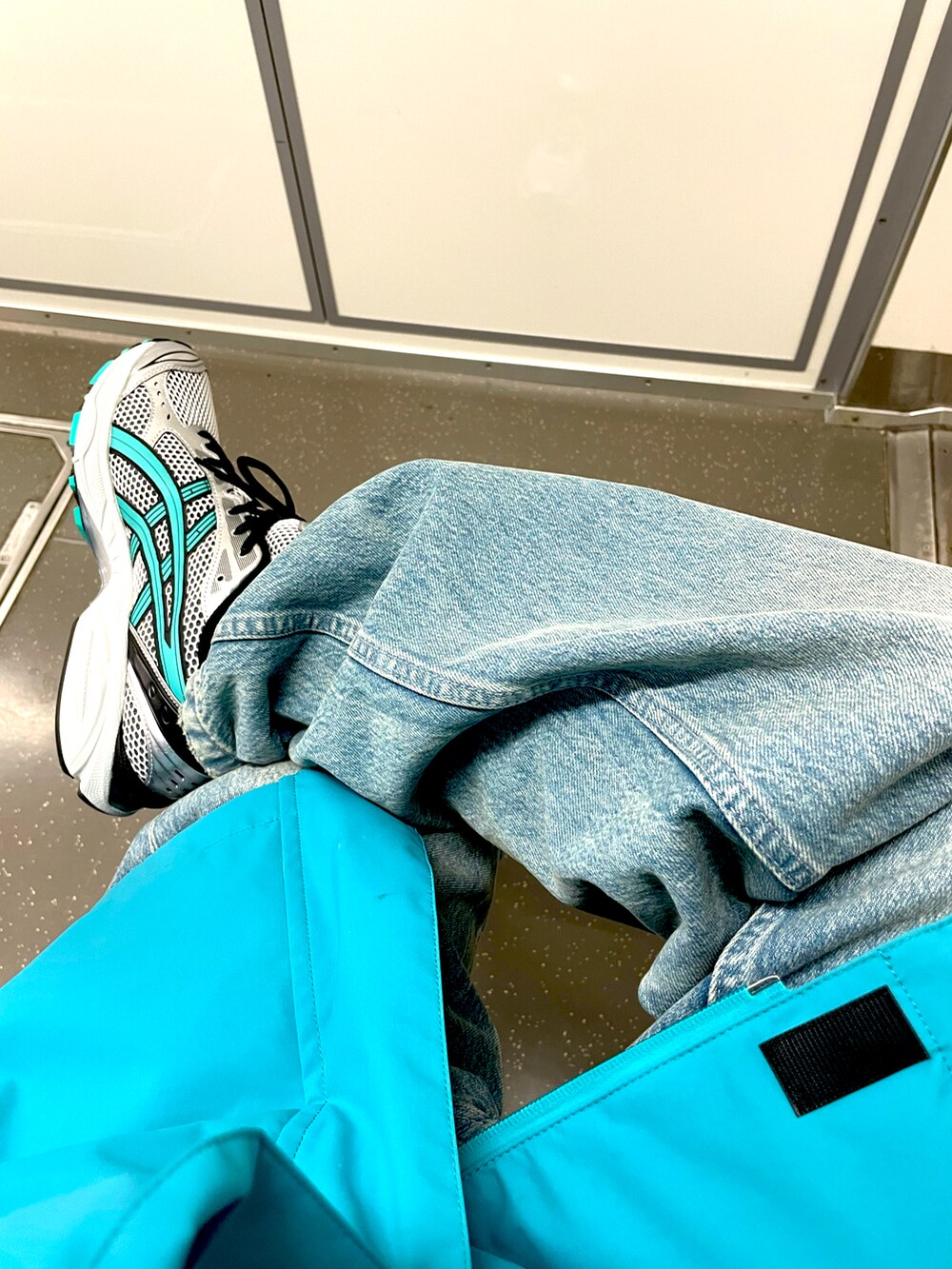 グリーン系のスニーカー、ブルー系のデニムパンツ、グリーン系のマウンテンパーカーを着用したメンズの春コーディネートの2枚目の写真