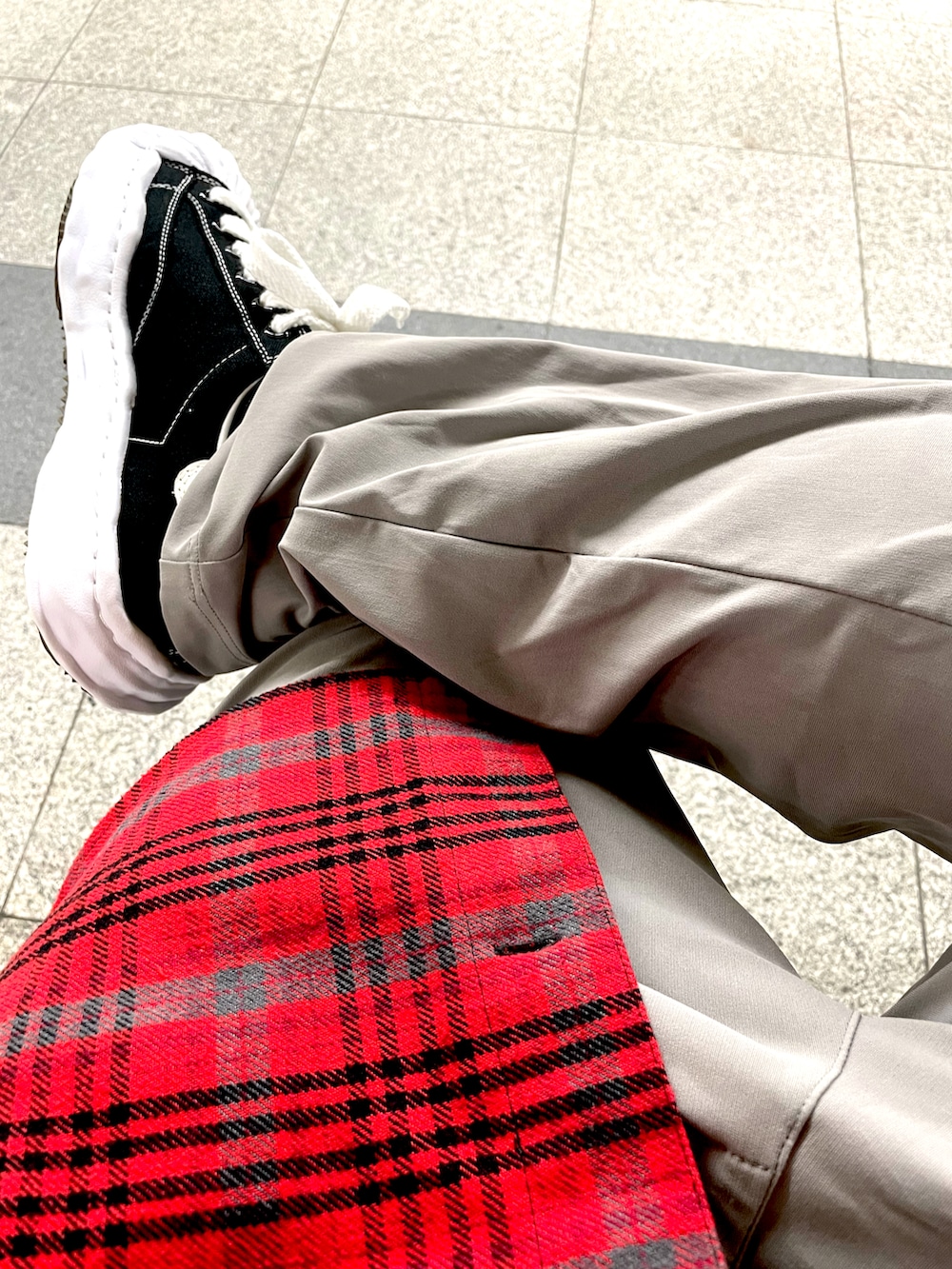 レッド系のその他アウター、グレー系のスラックス、ブラック系のスニーカーを着用したメンズの秋コーディネートの3枚目の写真