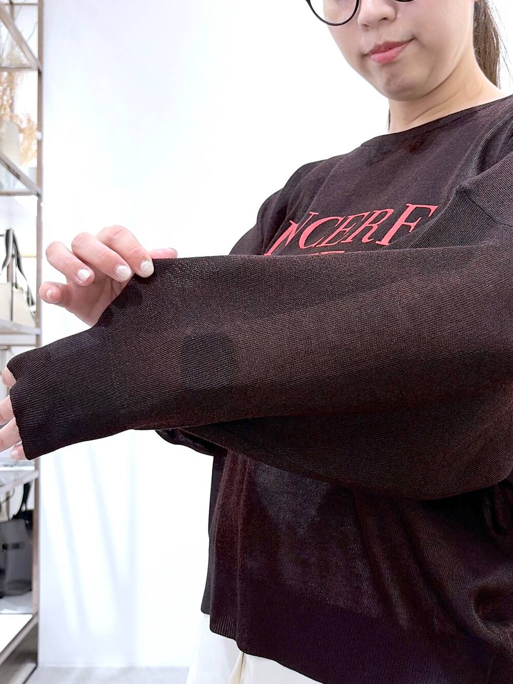 ブラック系のハンドバッグ、グリーン系のその他パンツ、ホワイト系のタンクトップを着用したレディースの春コーディネートの6枚目の写真