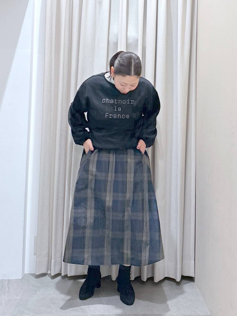 ブラック系のスウェット、ホワイト系のTシャツ/カットソー、グレー系のブーツを着用したレディースの秋コーディネートの6枚目の写真