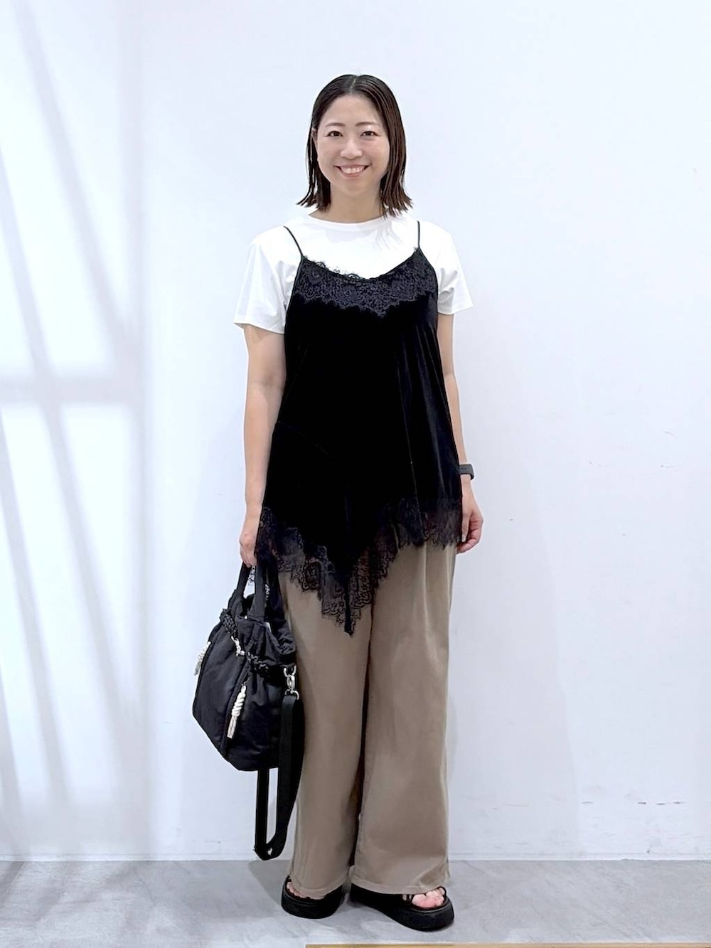 ホワイト系のTシャツ/カットソー、ブラック系のキャミソール、ブラック系のトートバッグを着用したレディースの夏コーディネートの2枚目の写真