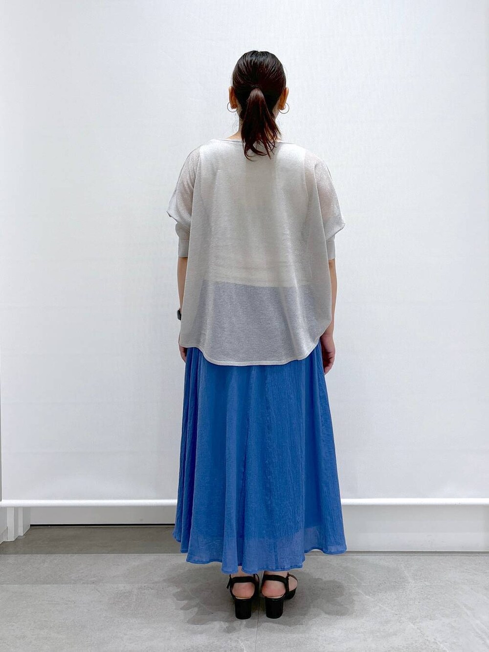 ブラック系のトートバッグ、グレー系のニット/セーター、ホワイト系のタンクトップを着用したレディースの夏コーディネートの4枚目の写真