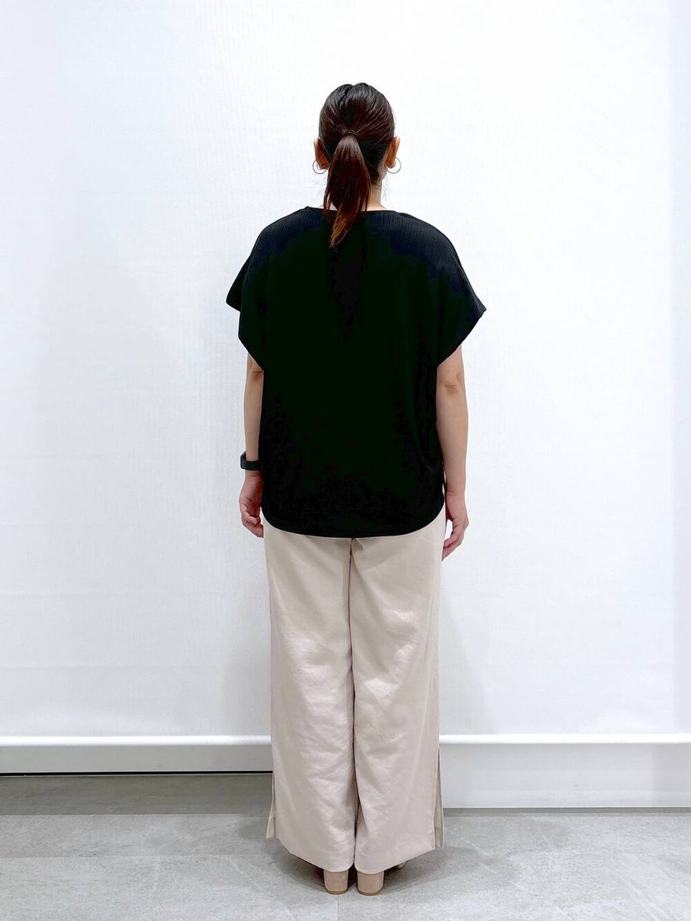 ベージュ系のその他パンツ、ブラック系のTシャツ/カットソー、ベージュ系のサンダルを着用したレディースの夏コーディネートの4枚目の写真