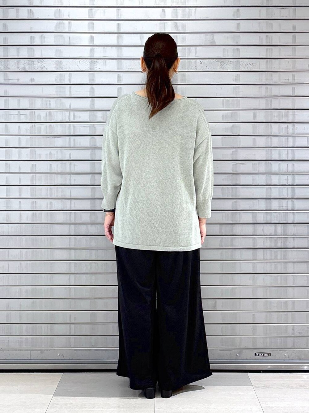 ブラック系のハンドバッグ、ブラック系のその他パンツ、グリーン系のニット/セーターを着用したレディースの春コーディネートの4枚目の写真