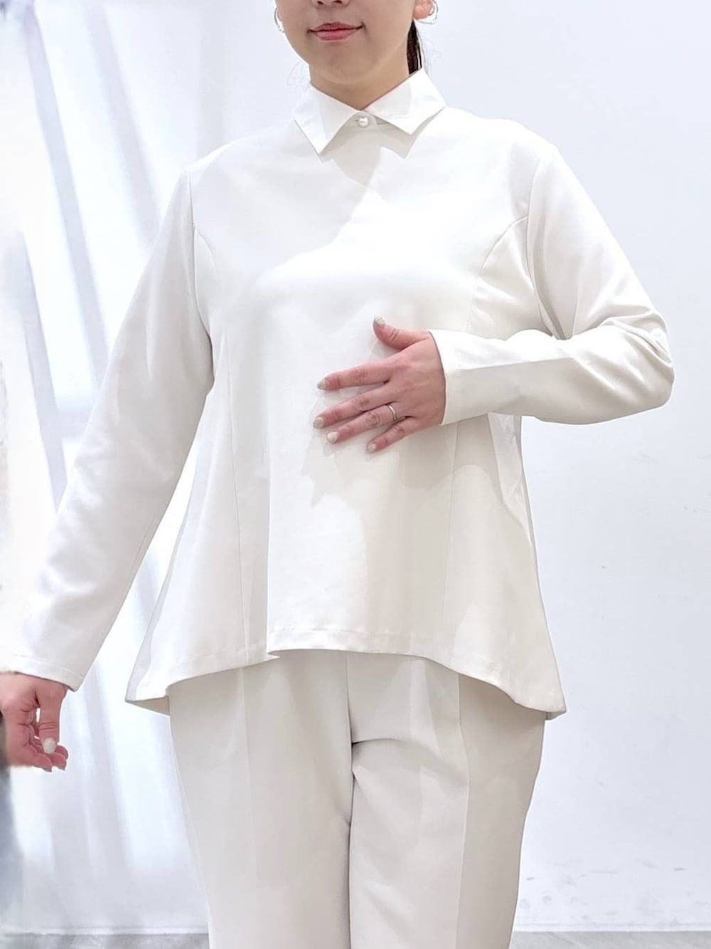 ブラック系のハンドバッグ、ホワイト系のシャツ/ブラウス、ホワイト系のスラックスを着用したレディースの春コーディネートの6枚目の写真