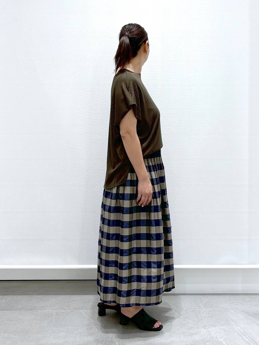 ブラック系のサンダル、グリーン系のTシャツ/カットソー、グリーン系のスカートを着用したレディースの夏コーディネートの6枚目の写真