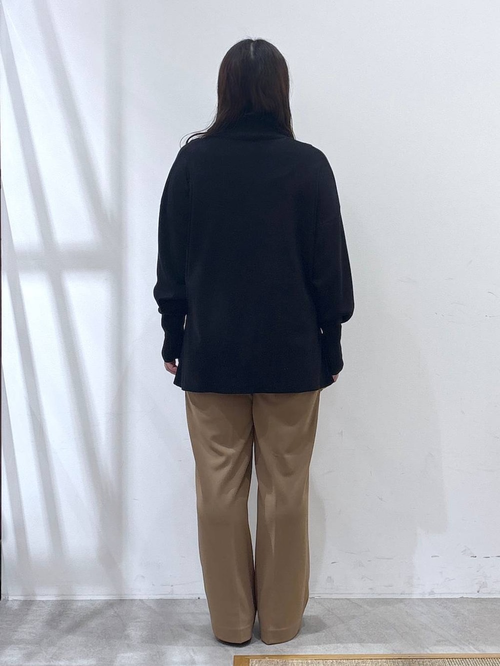 ブラック系のパンプス、ブラック系のニット/セーター、イエロー系のその他パンツを着用したレディースの冬コーディネートの4枚目の写真