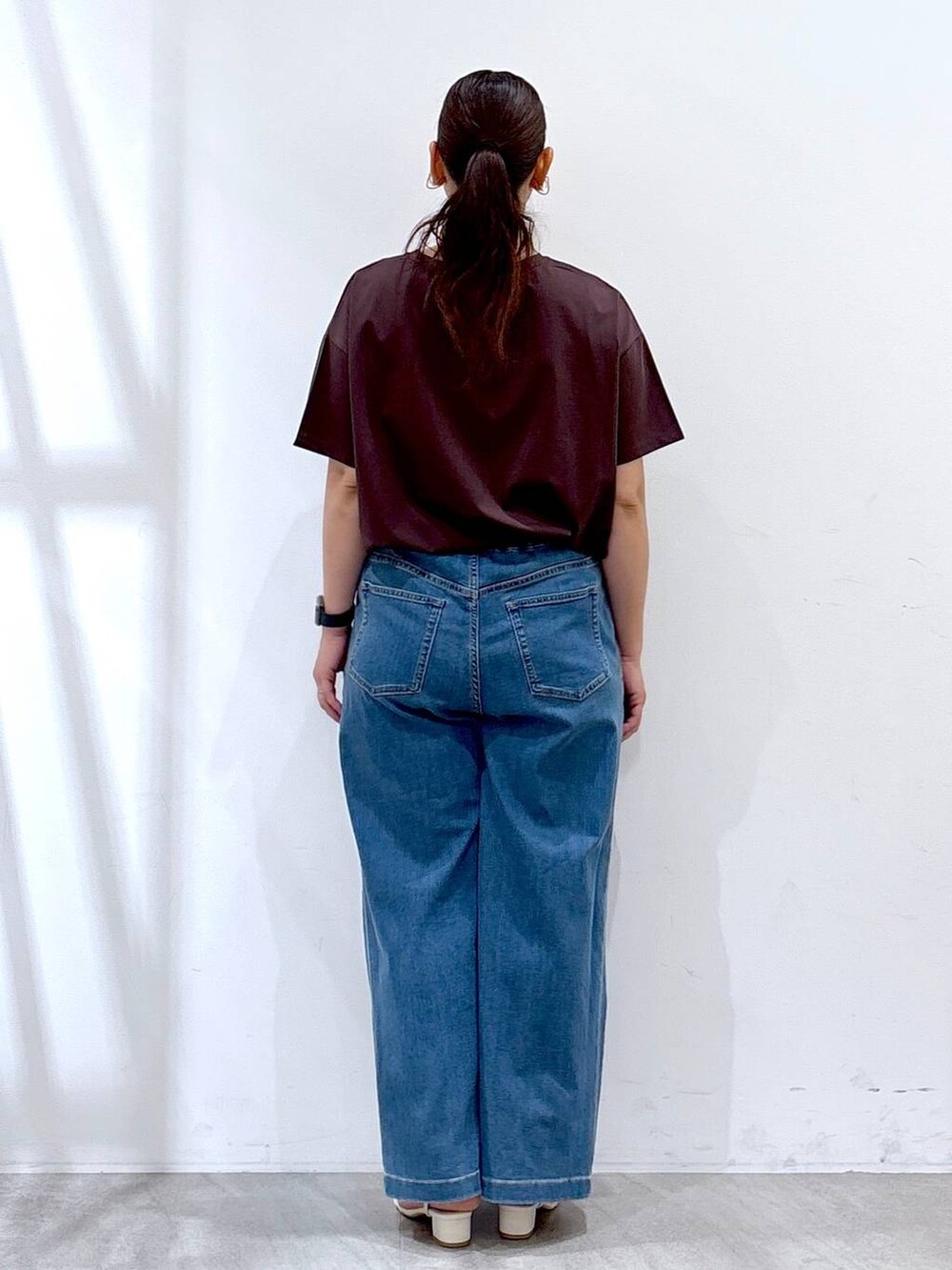 ホワイト系のトートバッグ、ブルー系のデニムパンツ、ブラウン系のTシャツ/カットソーを着用したレディースの夏コーディネートの4枚目の写真
