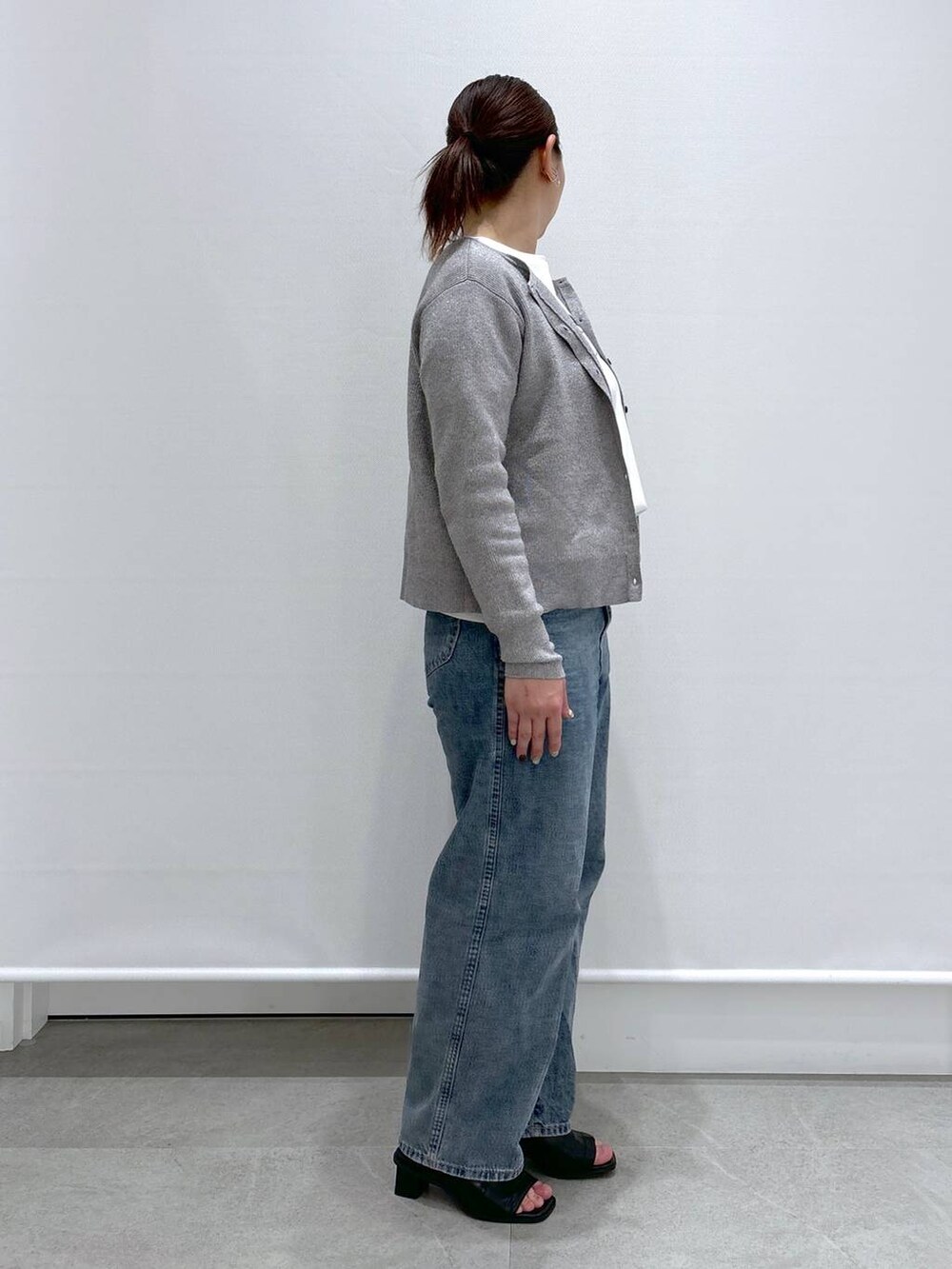 グレー系のカーディガン/ボレロ、ブルー系のデニムパンツ、ブラック系のサンダルを着用したレディースの春コーディネートの4枚目の写真