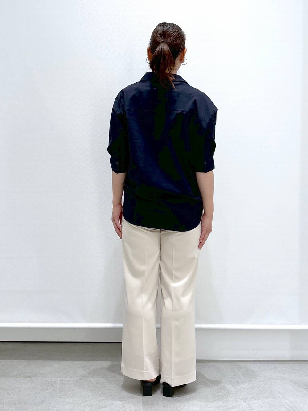 ホワイト系のその他パンツ、ブラック系のサンダル、ブラック系のハンドバッグを着用したレディースの春コーディネートの4枚目の写真