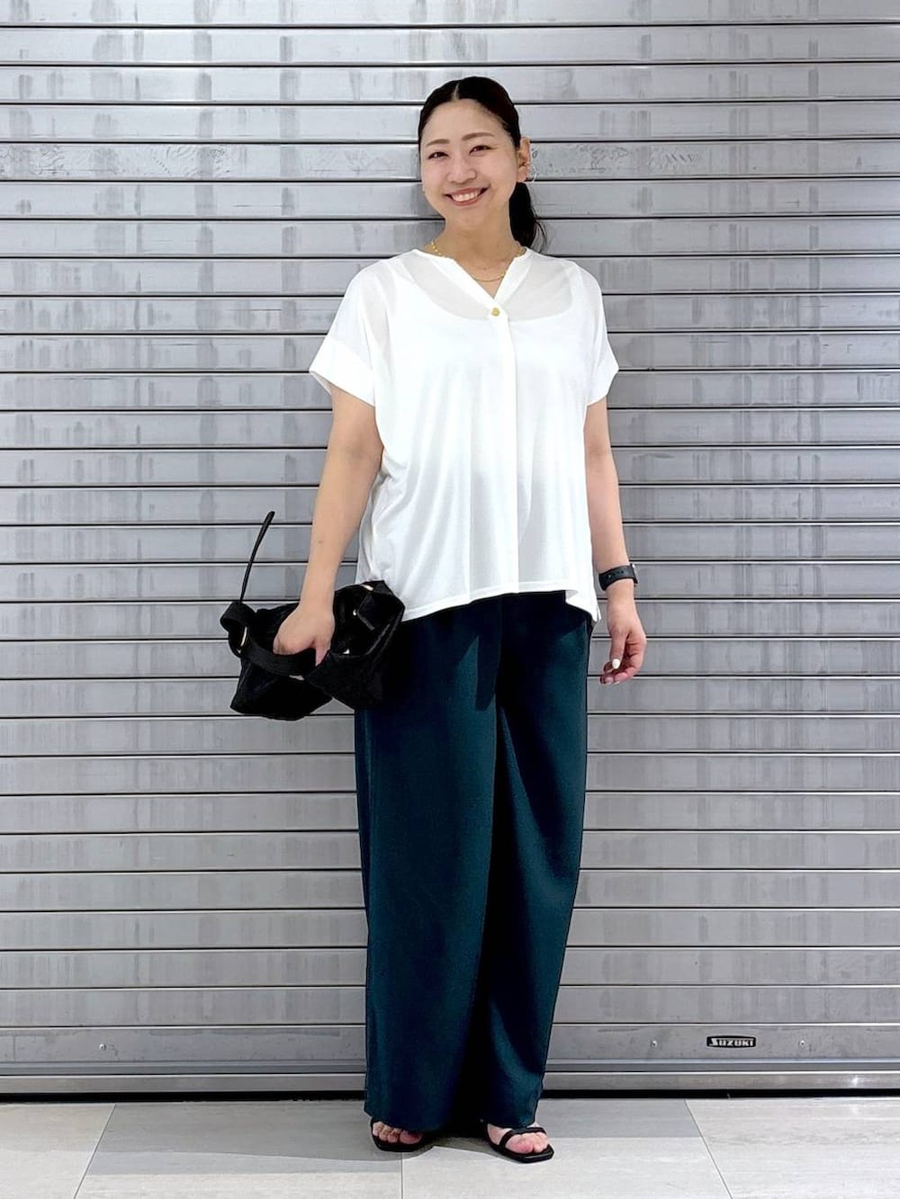 ホワイト系のTシャツ/カットソー、ブラック系のサンダルを着用したレディースの夏コーディネートの2枚目の写真