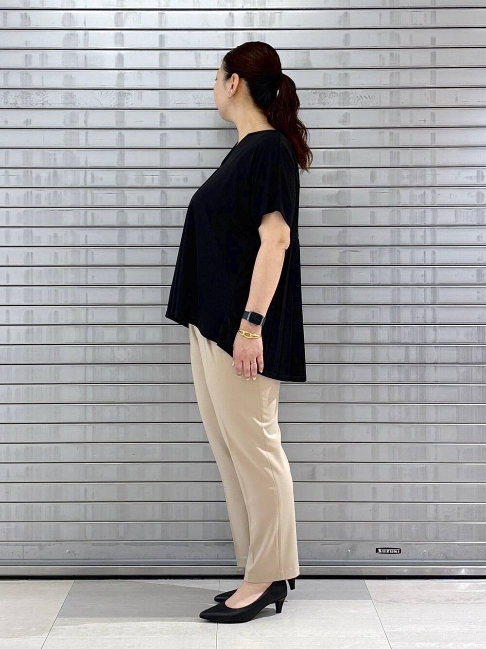 ブラック系のパンプス、ブラック系のハンドバッグ、ベージュ系のその他パンツを着用したレディースの春コーディネートの3枚目の写真