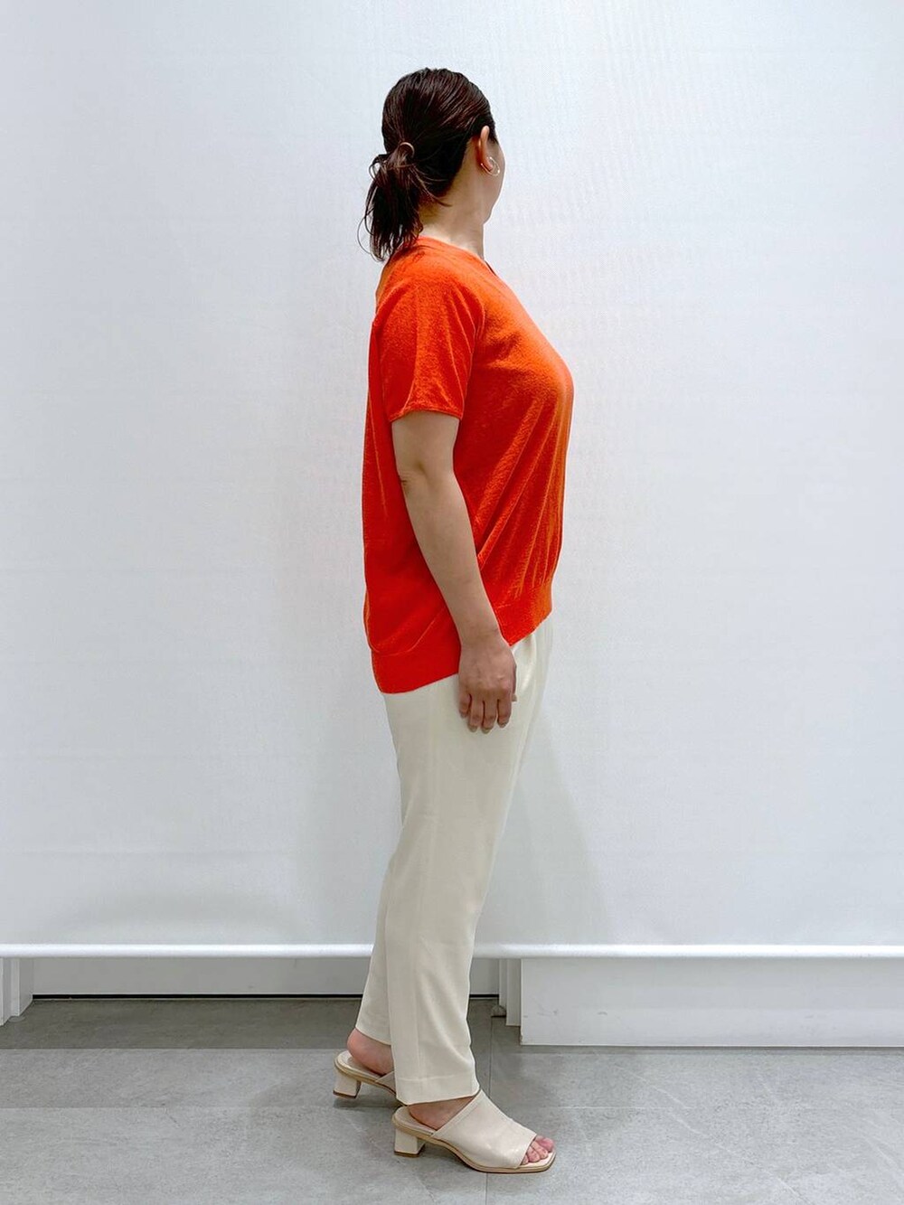 ホワイト系のサンダル、オレンジ系のニット/セーター、ホワイト系のその他パンツを着用したレディースの春コーディネートの3枚目の写真