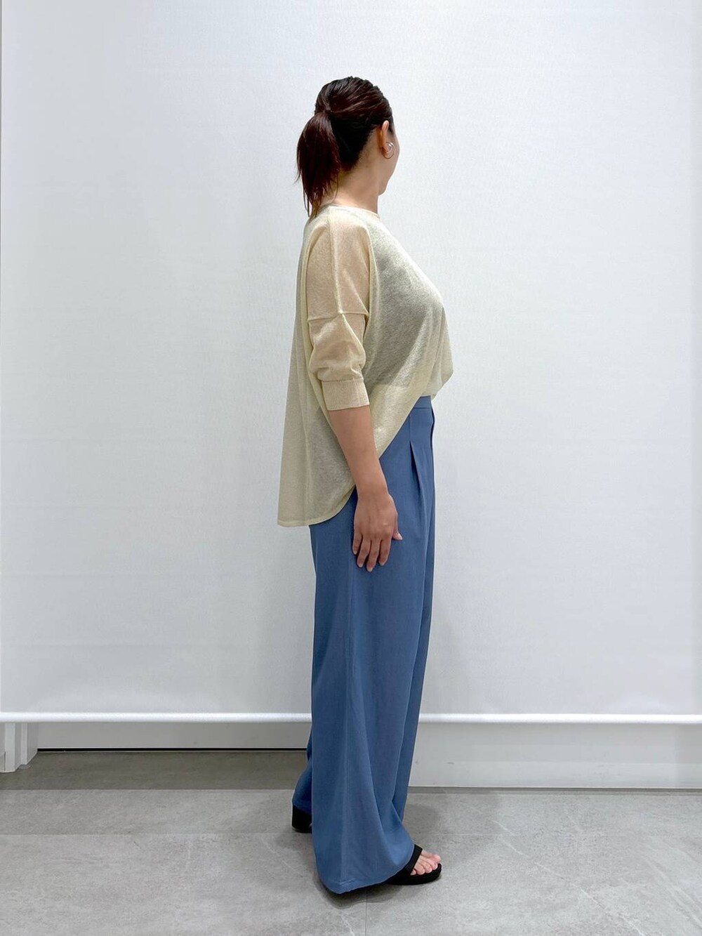 ブルー系のデニムパンツ、ベージュ系のニット/セーター、ブルー系のデニムパンツを着用したレディースの夏コーディネートの4枚目の写真