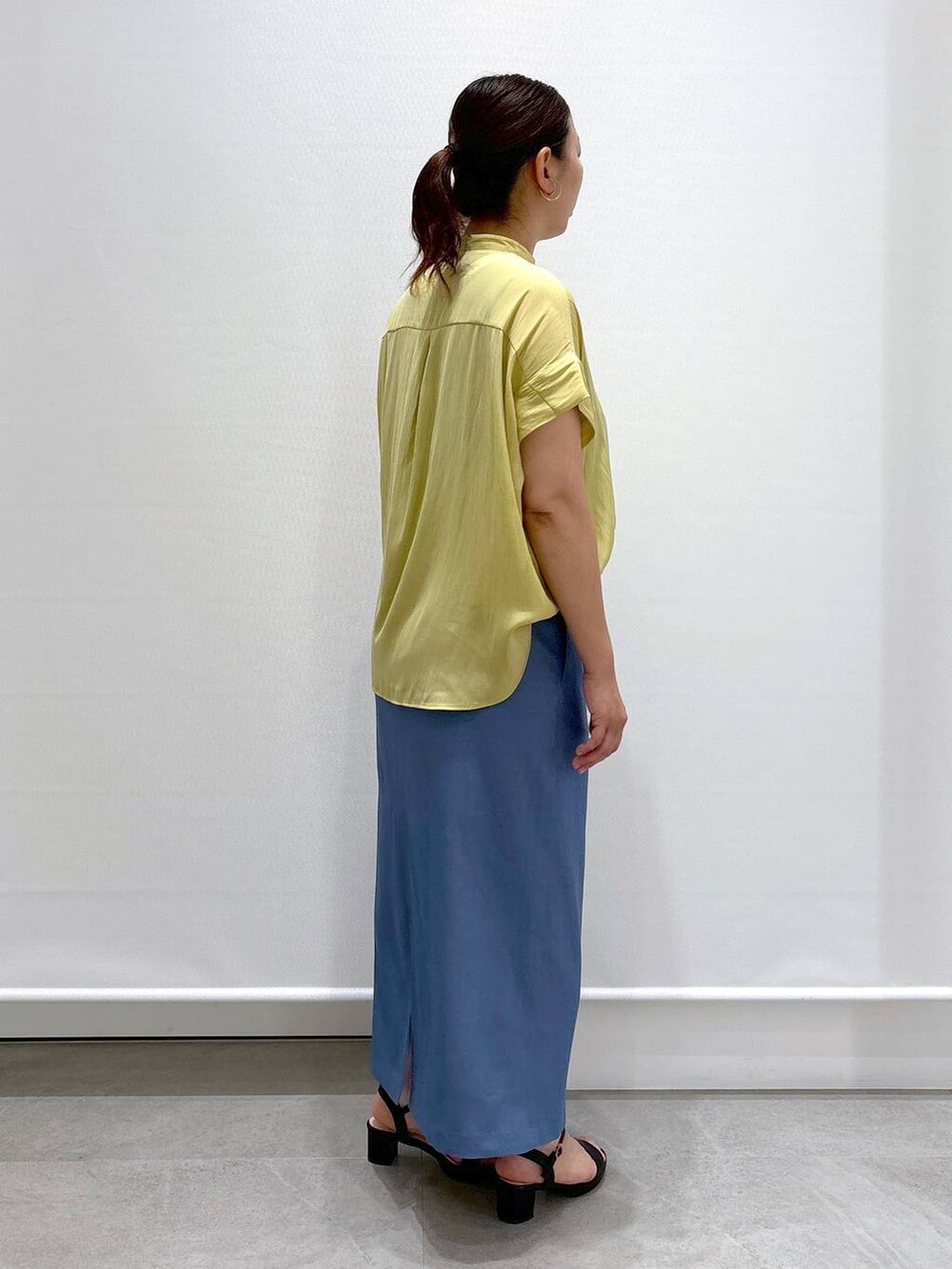 イエロー系のシャツ/ブラウス、ブラック系のサンダル、ブラック系のハンドバッグを着用したレディースの夏コーディネートの5枚目の写真