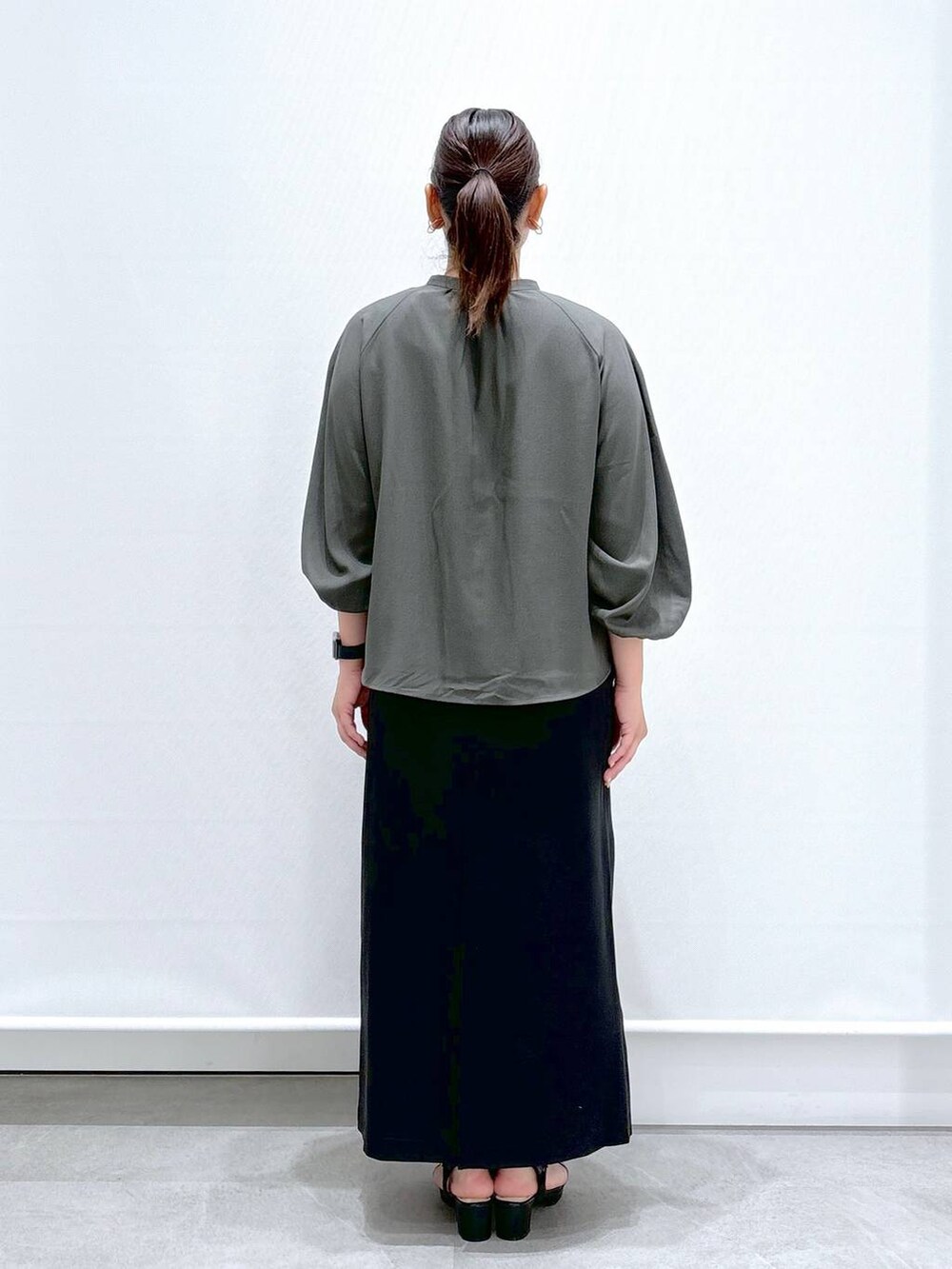 グリーン系のシャツ/ブラウス、ブラック系のサンダル、ブラック系のスカートを着用したレディースの秋コーディネートの3枚目の写真