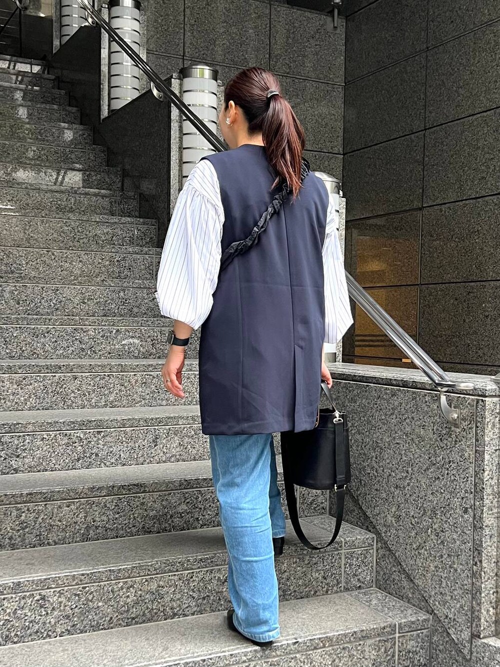 ブルー系のスーツベスト、ブルー系のデニムパンツを着用したレディースの春コーディネートの4枚目の写真