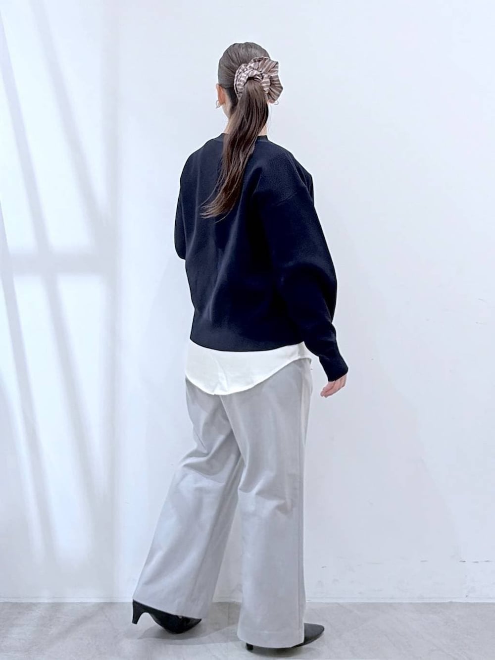 ブラック系のハンドバッグ、グレー系のその他パンツ、ブルー系のカーディガン/ボレロを着用したレディースの春コーディネートの5枚目の写真