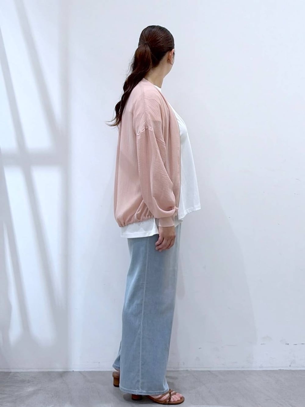 ブラウン系のサンダル、ホワイト系のTシャツ/カットソー、ブルー系のデニムパンツを着用したレディースの夏コーディネートの5枚目の写真