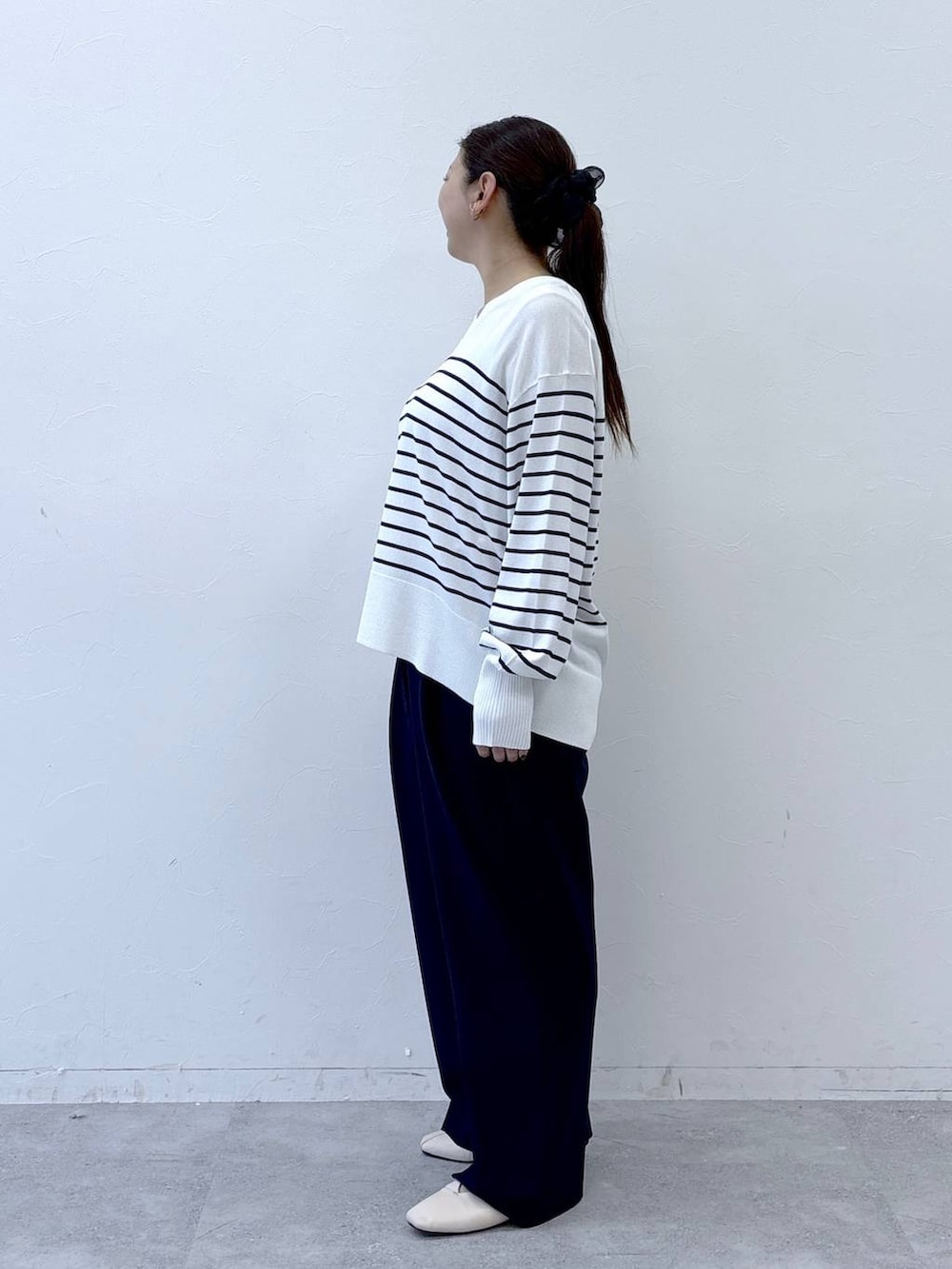 ホワイト系のパンプス、ベージュ系のショルダーバッグ、ブルー系のその他パンツを着用したレディースの冬コーディネートの3枚目の写真