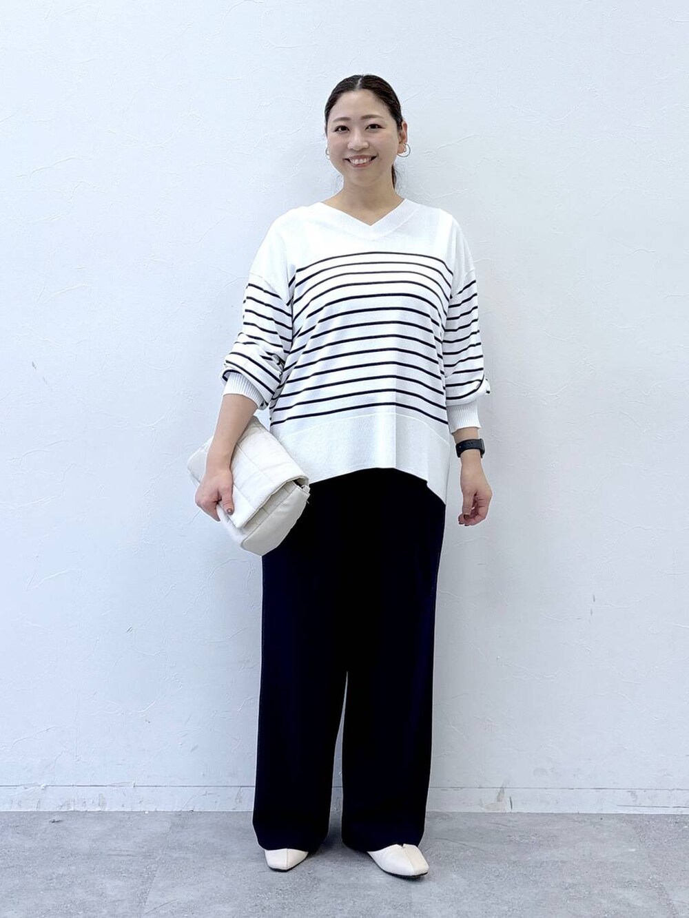 ホワイト系のパンプス、ベージュ系のショルダーバッグ、ブルー系のその他パンツを着用したレディースの冬コーディネートの2枚目の写真