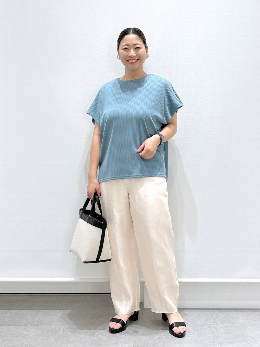 グリーン系のTシャツ/カットソー、ブラック系のサンダル、ホワイト系のその他パンツを着用したレディースの夏コーディネートの2枚目の写真