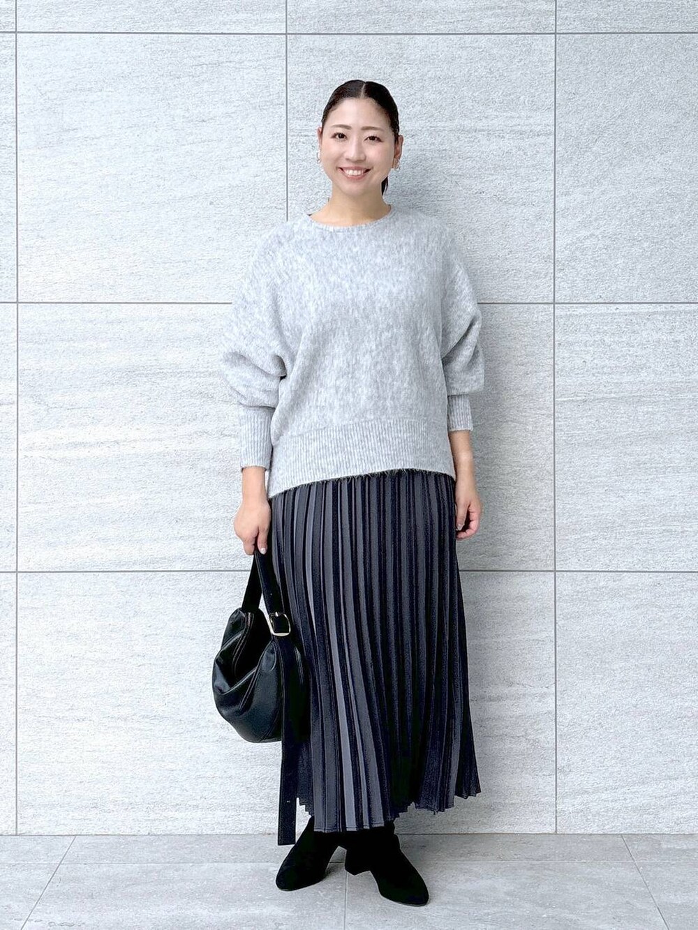 グレー系のブーツ、グレー系のスカート、グレー系のスカートを着用したレディースの秋コーディネートの2枚目の写真