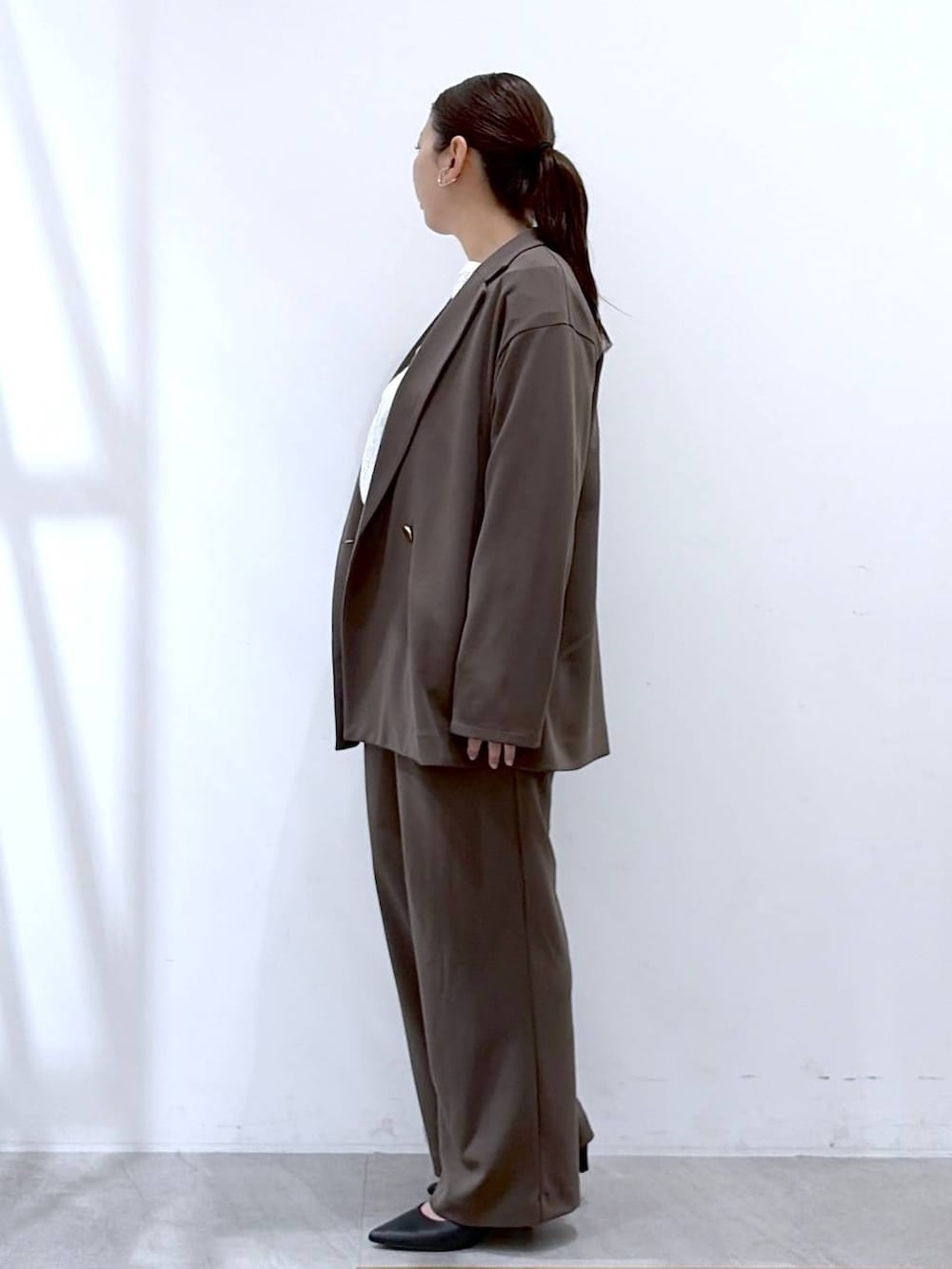 ブラウン系のその他パンツ、ブラック系のハンドバッグ、ブラウン系のテーラードジャケットを着用したレディースの春コーディネートの3枚目の写真