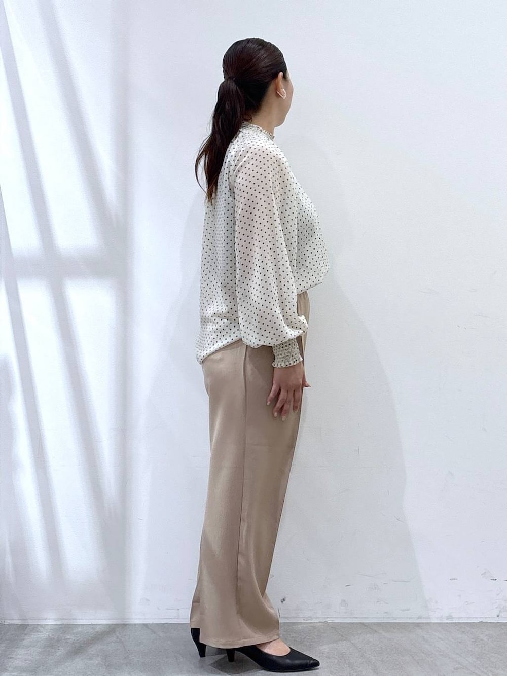 ブラック系のパンプス、ブラック系のカーディガン/ボレロ、ブラック系のハンドバッグを着用したレディースの秋コーディネートの6枚目の写真