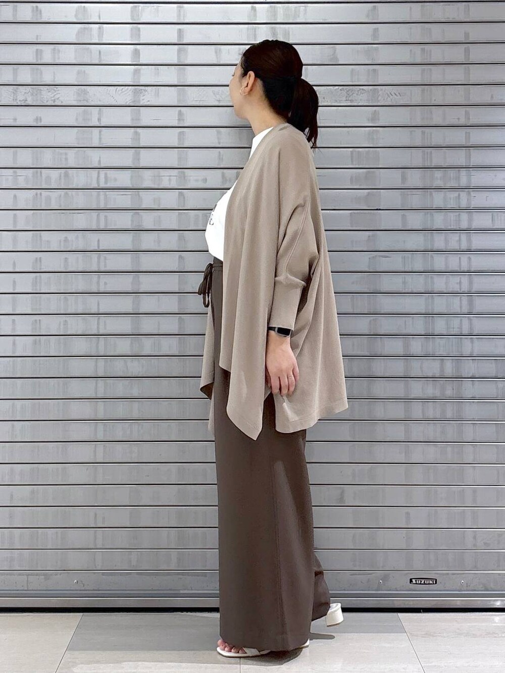 ベージュ系のハンドバッグ、ブラウン系のその他パンツ、ホワイト系のTシャツ/カットソーを着用したレディースの春コーディネートの3枚目の写真