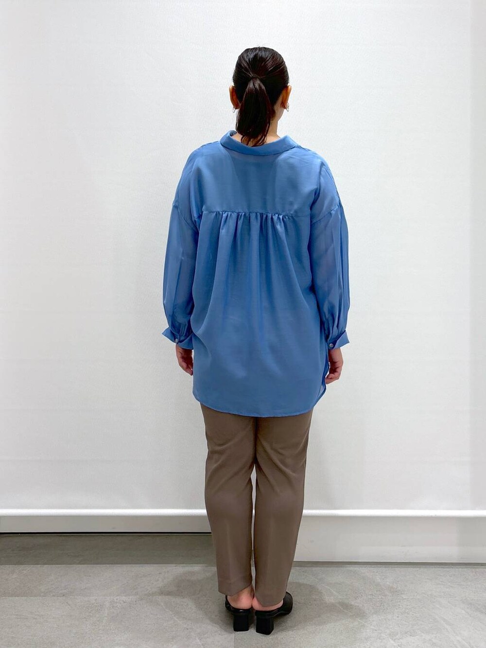 ブラック系のサンダル、ブラック系のトートバッグ、ブルー系のシャツ/ブラウスを着用したレディースの夏コーディネートの3枚目の写真