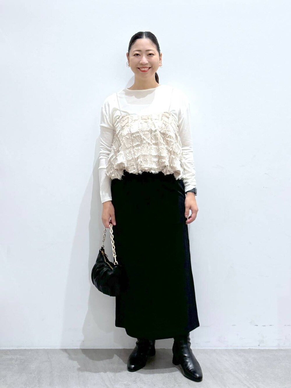 ブラック系のスカート、ブラック系のスカート、ホワイト系のTシャツ/カットソーを着用したレディースの秋コーディネートの2枚目の写真