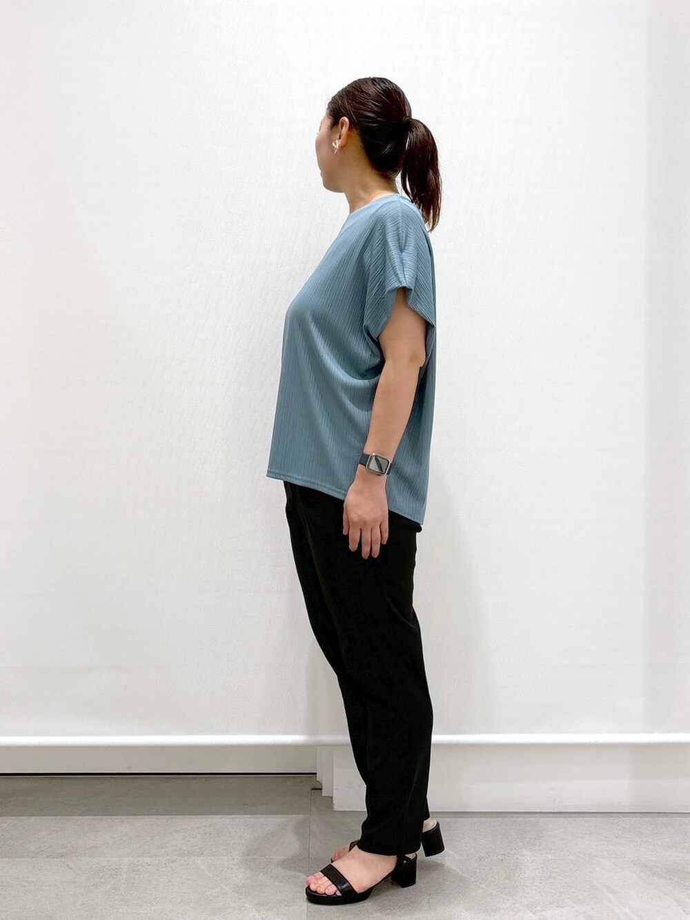 ゴールド系のトートバッグ、ブラック系のその他パンツ、グリーン系のTシャツ/カットソーを着用したレディースの秋コーディネートの3枚目の写真