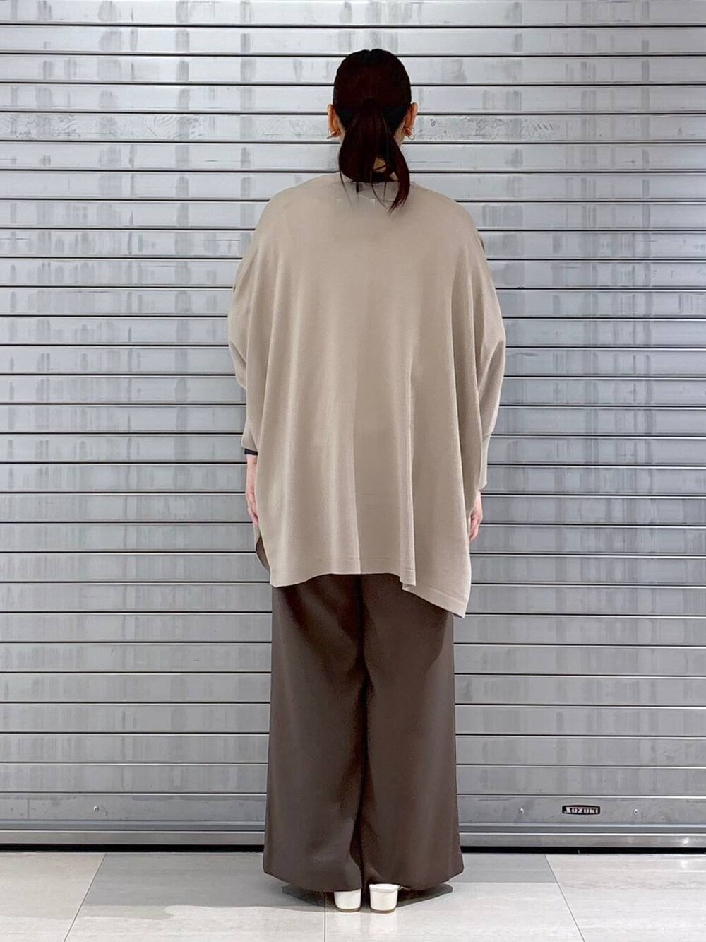 ベージュ系のハンドバッグ、ブラウン系のその他パンツ、ホワイト系のTシャツ/カットソーを着用したレディースの春コーディネートの4枚目の写真