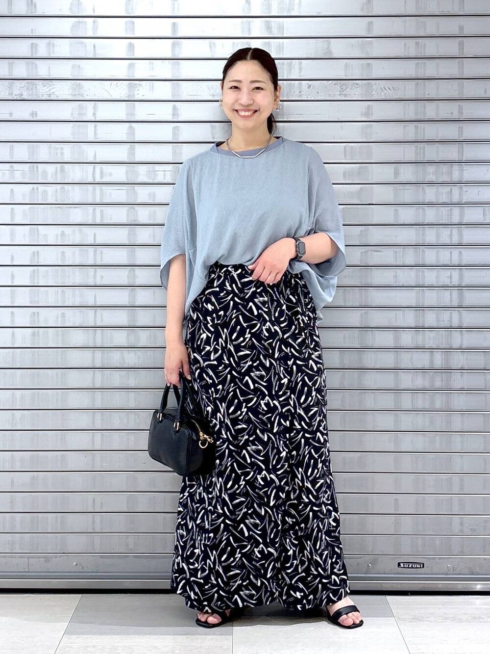 ブラック系のその他パンツ、ブルー系のTシャツ/カットソー、ブラック系のハンドバッグを着用したレディースの春コーディネートの2枚目の写真
